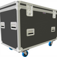 Shadow Grey flight case with silver handles and blue wheels on a white background
